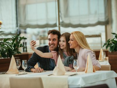 Happy family taking a selfie in a restaurant