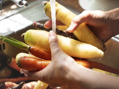 Chef cleaning carrots and turnips in the sink