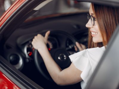 Lady in a car salon. Woman buying the car. Elegant woman in a dress