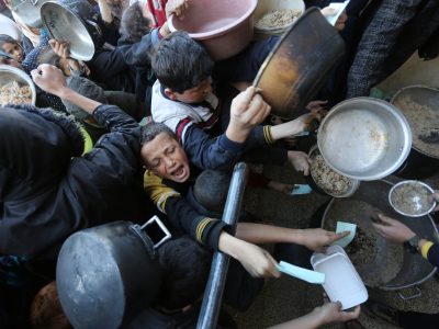 Niños desesperados luchan por su cuenco de comida, verdaderos pelotones del hambre en Gaza.  El Museo Nacional Thyssen-Bornemisza presenta Gaza a través de sus ojos, una exposición de fotografías tomadas por fotoperiodistas que desde octubre de 2023, documentan la vida en la franja bajo el brutal asedio. Foto sin firma. El Museo Nacional Thyssen-Bornemisza